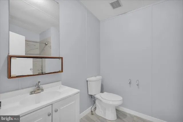 a bathroom with a sink mirror and toilet