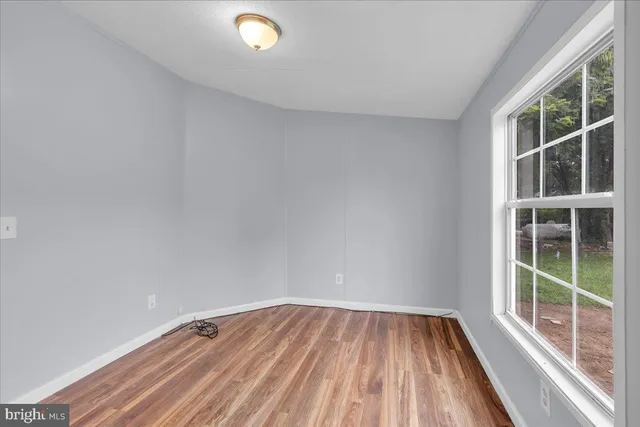 a view of a room with wooden floor and windows