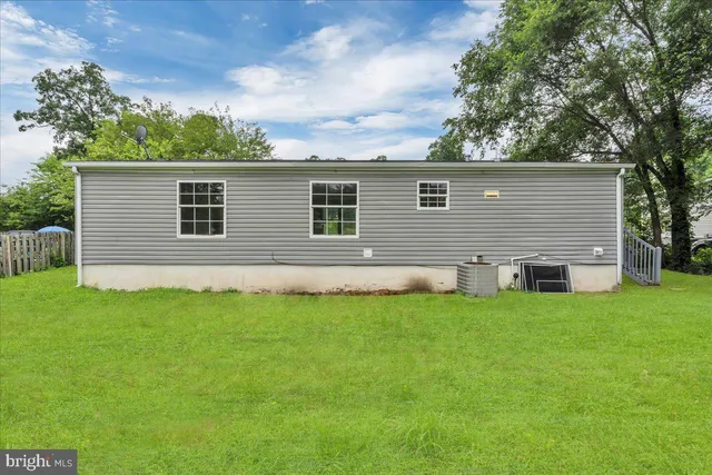 a front view of house with yard and trees in the background