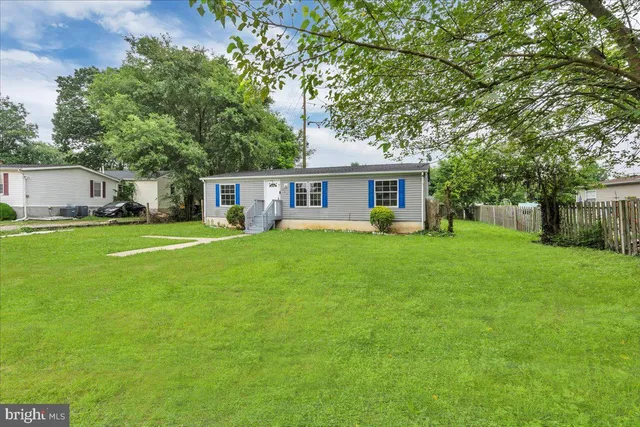 a view of a house with a big yard and large trees