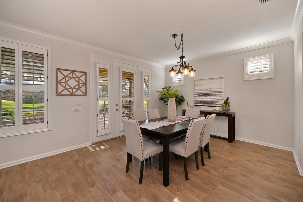 6014 Timberlodge Lane Roseville, CA 95747 - Photo 12 of 63 a dining room with wooden floor a chandelier a wooden table and chairs
