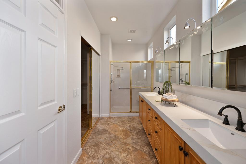 6014 Timberlodge Lane Roseville, CA 95747 - Photo 32 of 63 a bathroom with a double vanity sink a mirror and shower