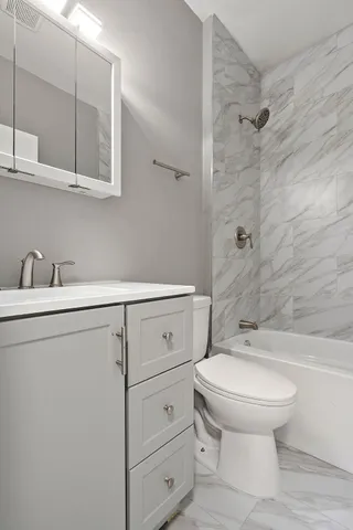 a bathroom with a sink a toilet and shower