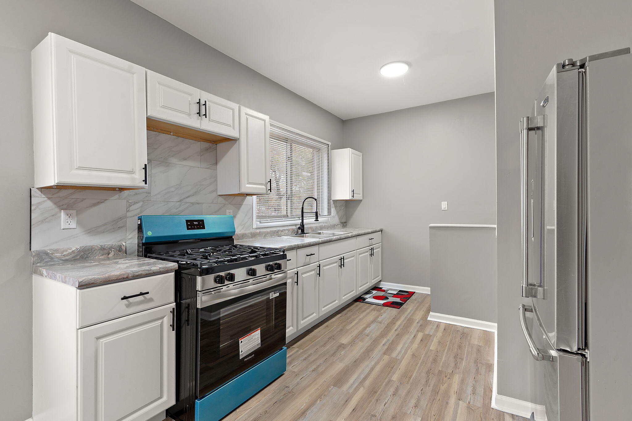 1335 Williams Street Gary, IN 46404 - Photo 7 of 22 a kitchen with stainless steel appliances a stove and white cabinets
