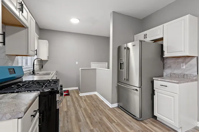 a kitchen with a refrigerator and a stove top oven
