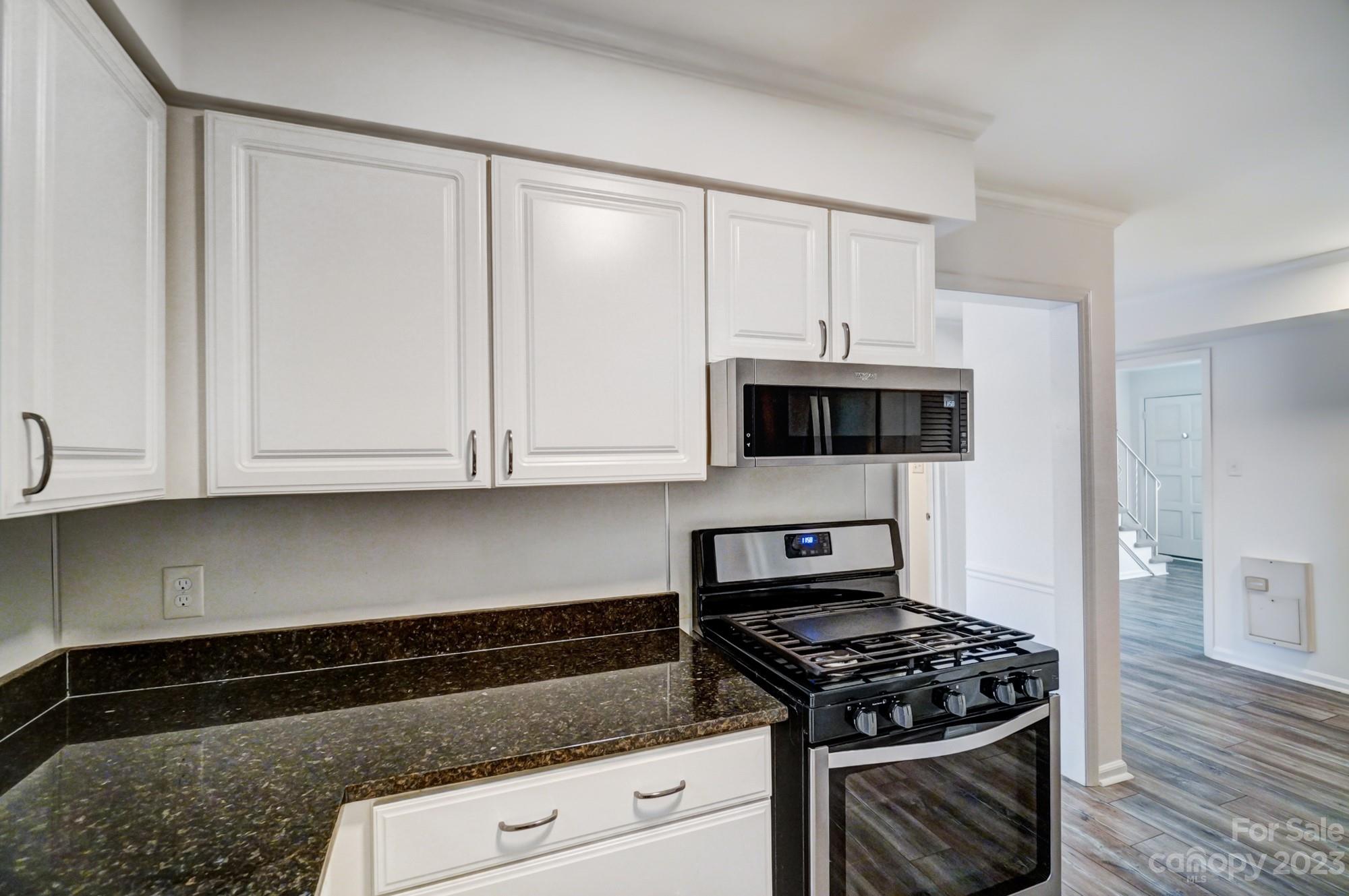 3500 Colony Road, Unit E Charlotte, NC 28211 - Photo 12 of 37 a kitchen with granite countertop white cabinets and stainless steel appliances