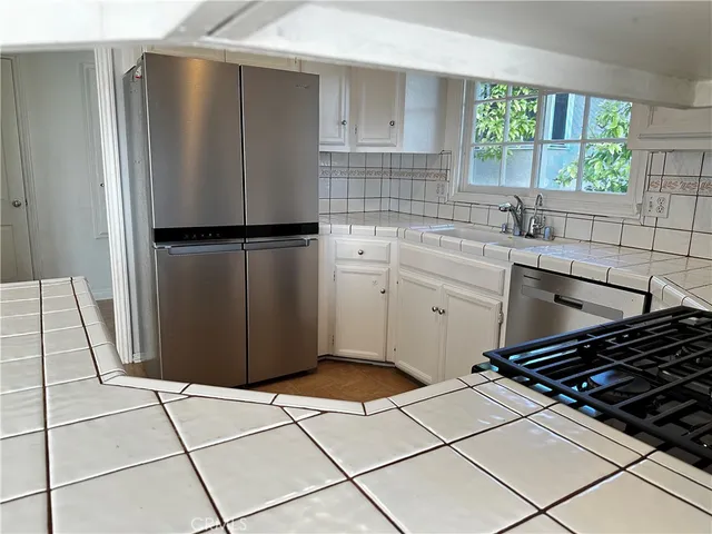 a kitchen with a refrigerator a sink and cabinets