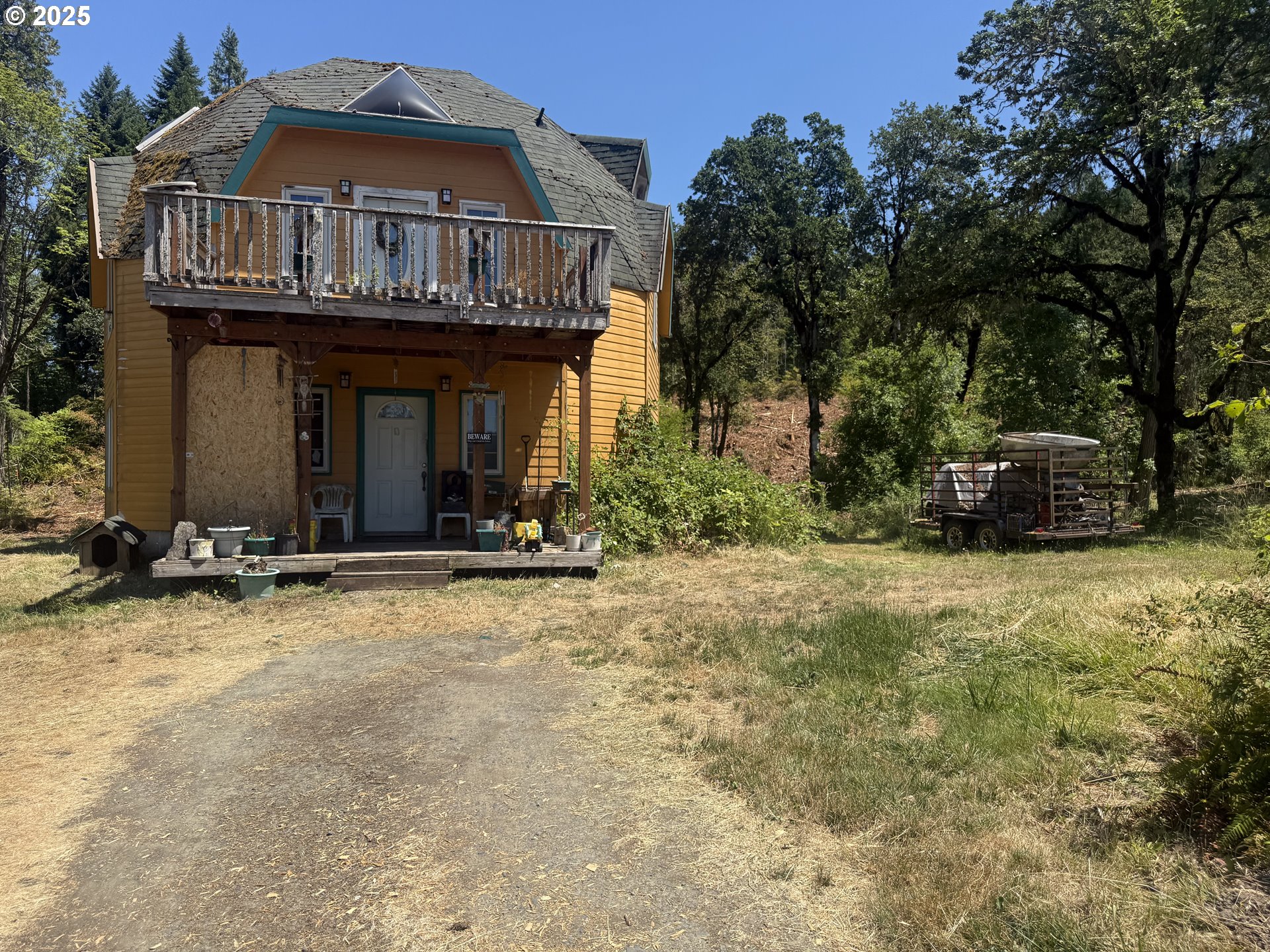 a view of a house with large trees and plants