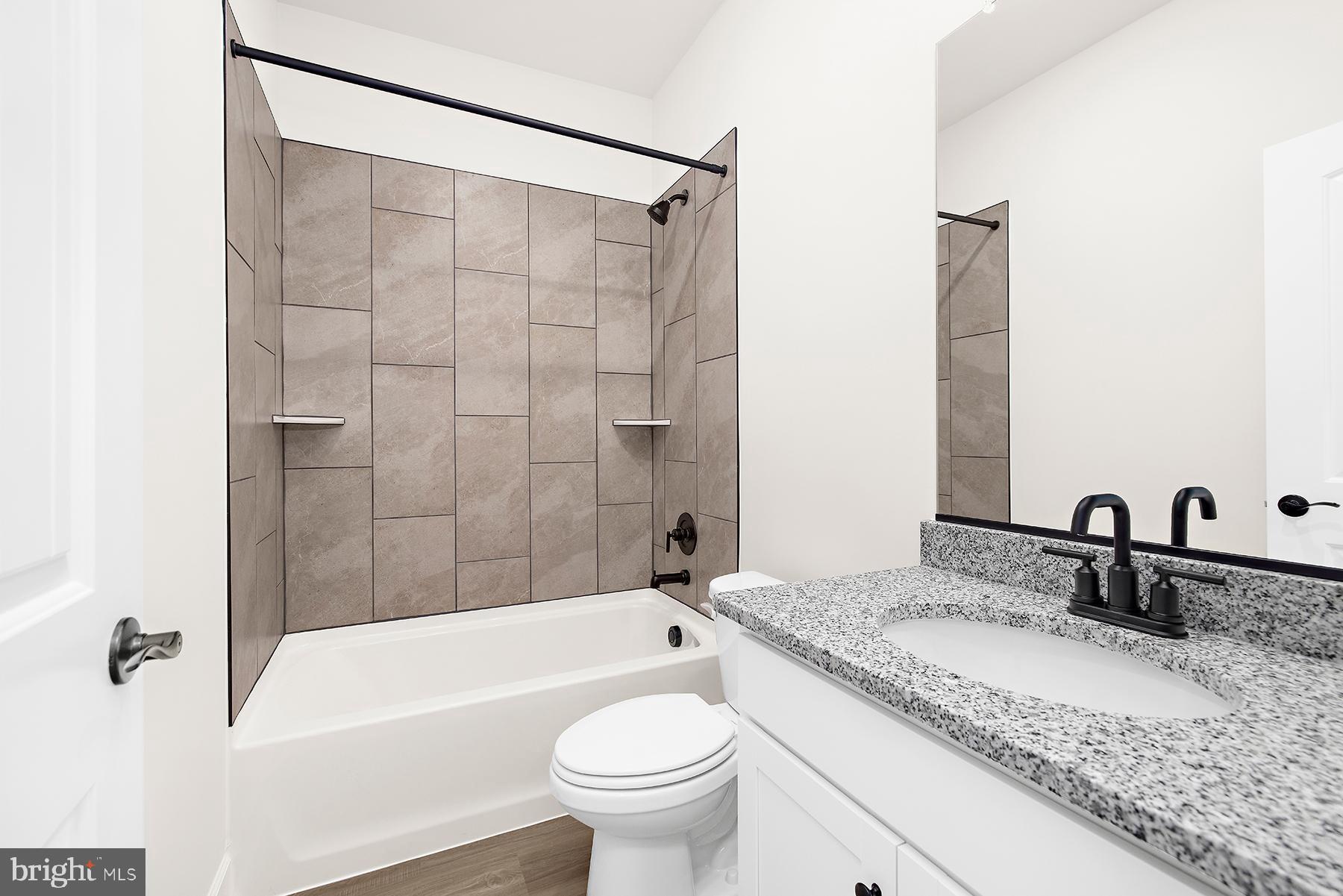5211 McCormick Avenue Baltimore, MD 21206 - Photo 19 of 20 a bathroom with a granite countertop sink a toilet and bathtub