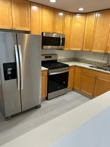 a kitchen with stainless steel appliances a stove a sink and a microwave