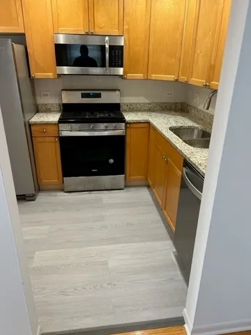 a kitchen with stainless steel appliances granite countertop a stove a microwave and a sink