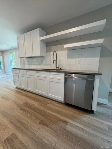 a kitchen with stainless steel appliances granite countertop a sink and a refrigerator