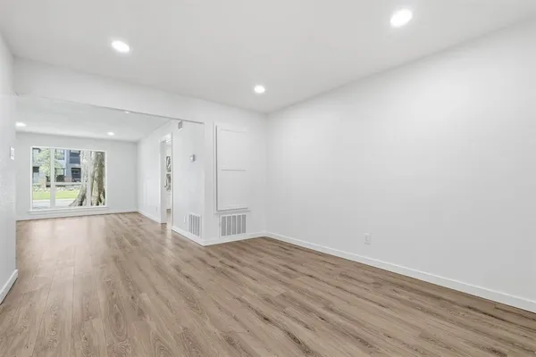 wooden floor in an empty room with a window