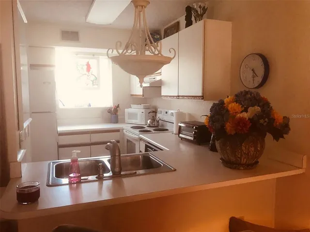 a kitchen with a sink cabinets and a window