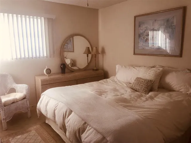 a bedroom with a bed and a painting on the wall