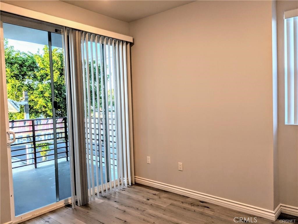7343 Reseda Boulevard, Unit 303 Reseda, CA 91335 - Photo 5 of 10 an empty room with wooden floor and windows