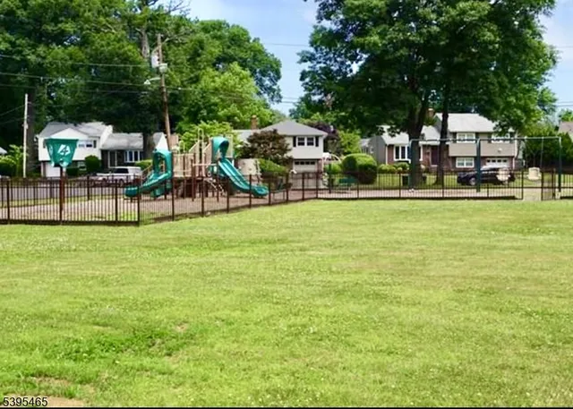 a view of a house with a big yard and large trees