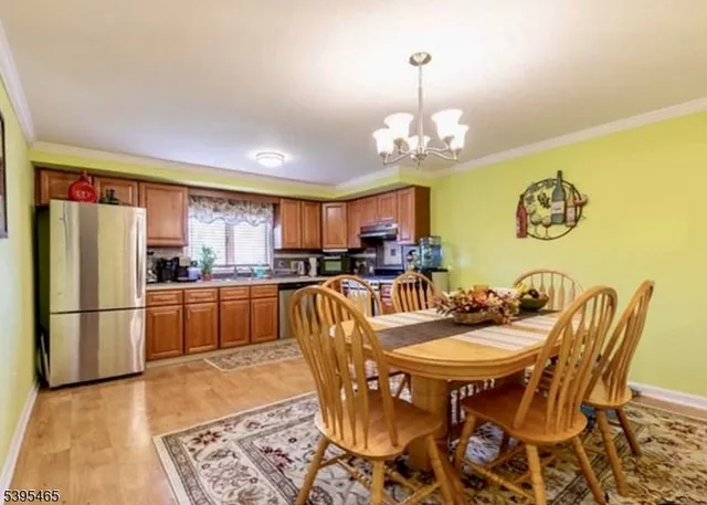 a kitchen with stainless steel appliances granite countertop a dining table and chairs
