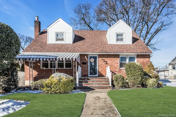 a front view of a house with a garden and plants