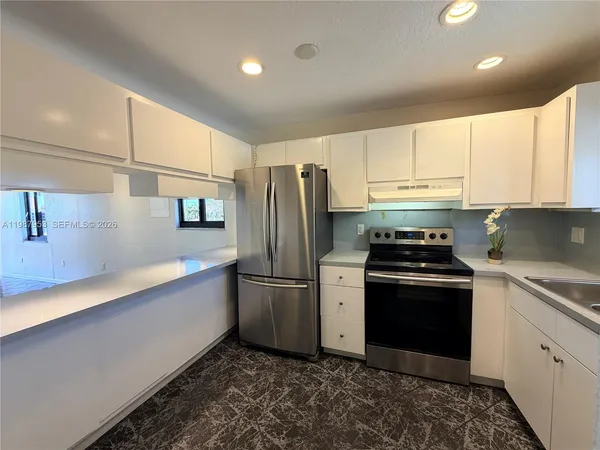 a kitchen with stainless steel appliances granite countertop a refrigerator sink and stove
