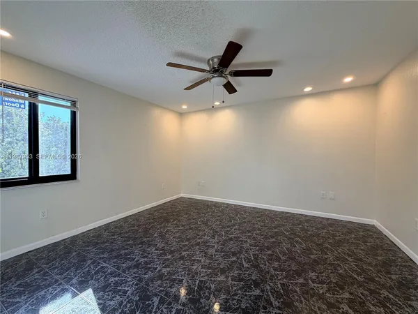 en empty room with wooden floor and windows