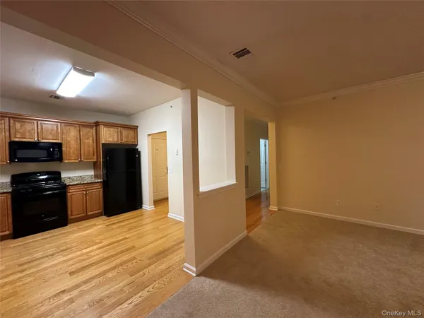a view of a kitchen with refrigerator stove and wooden floor