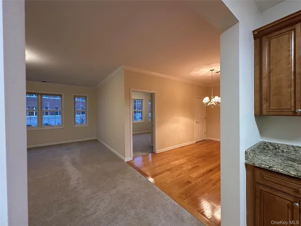 a view of a big room with window and chandelier fan