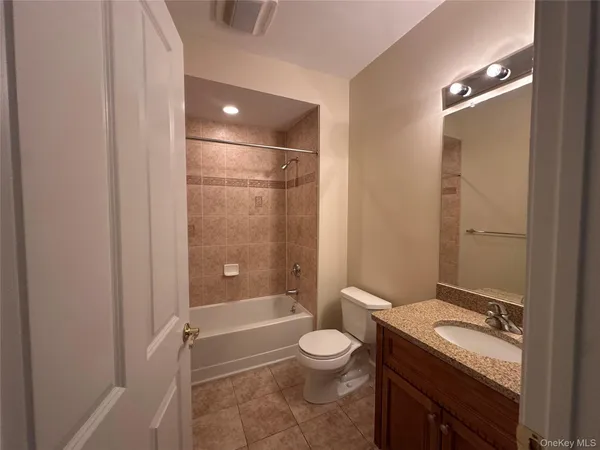 a spacious bathroom with a granite countertop sink a mirror and a toilet