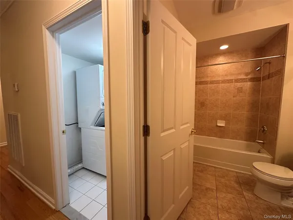 an empty room with ceiling fan and windows