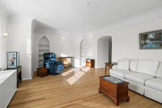 a living room with furniture kitchen view and a wooden floor