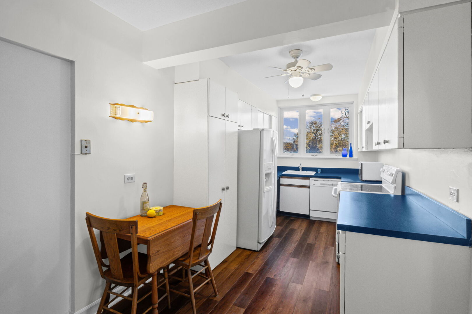 8037 Kenton Avenue, Unit 2S Skokie, IL 60076 - Photo 9 of 20 a kitchen with stainless steel appliances a dining table chairs refrigerator and sink