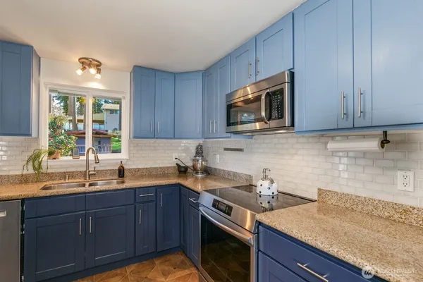 a kitchen with a sink stove and microwave