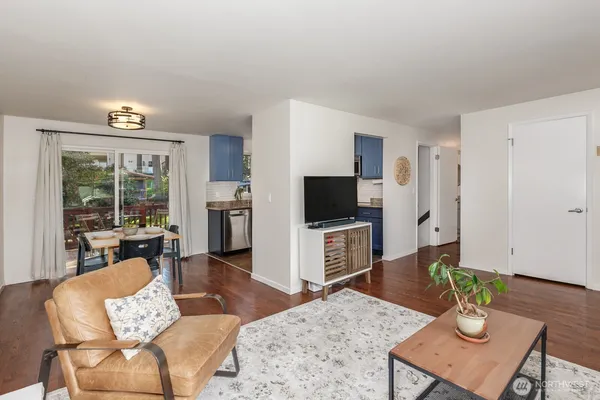 a living room with furniture a flat screen tv and a table