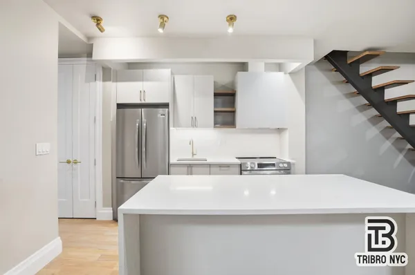 a kitchen with a sink a refrigerator and cabinets