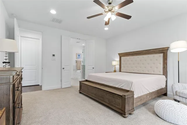 a spacious bedroom with a bed and a chandelier