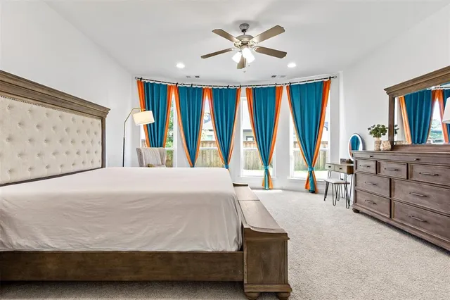 a spacious bedroom with a large bed and a chandelier