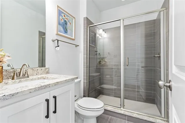 a bathroom with a granite countertop sink toilet and shower