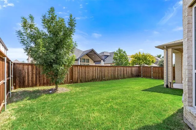 a view of a backyard with wooden fence and a fence