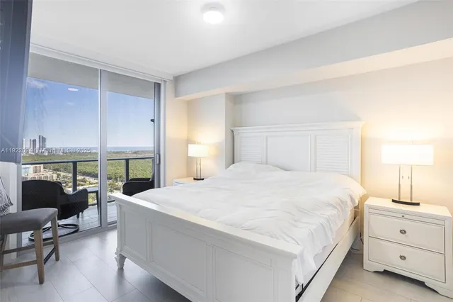 a bedroom with a bed and large windows