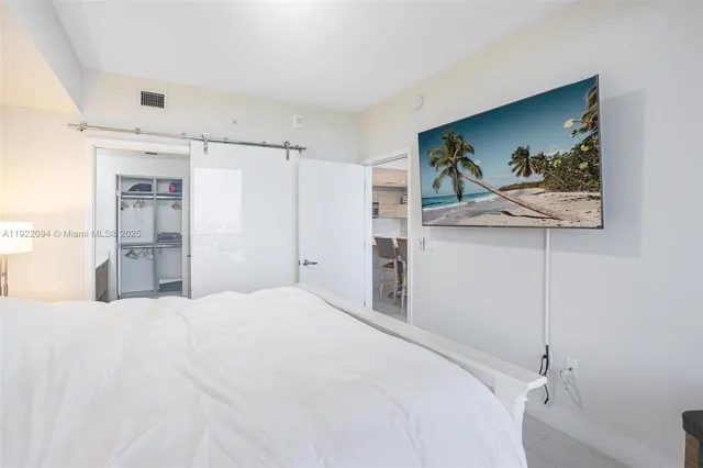 a bedroom with a bed and a painting on the wall