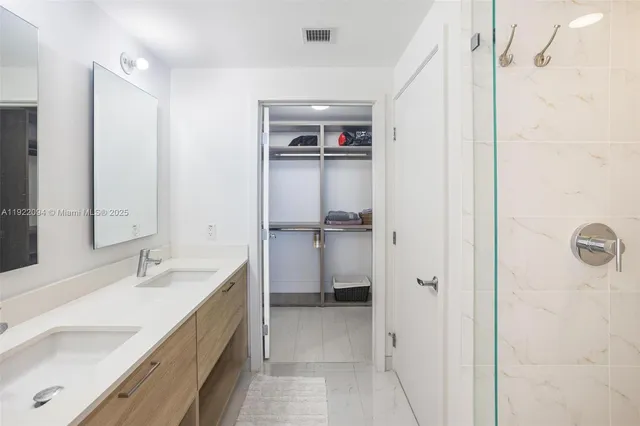 a bathroom with a double vanity sink mirror and shower