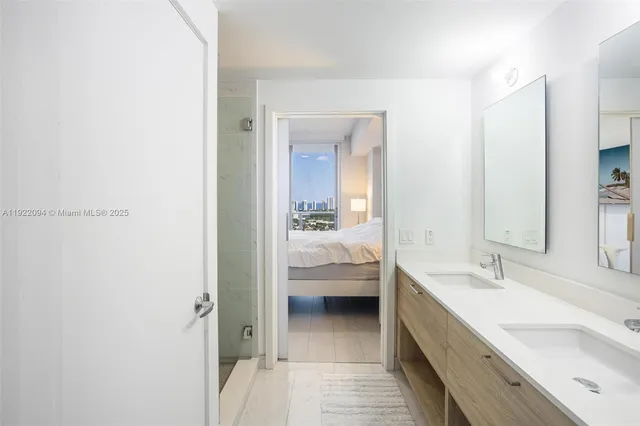 a en suite bathroom with a sink a mirror and a bathtub