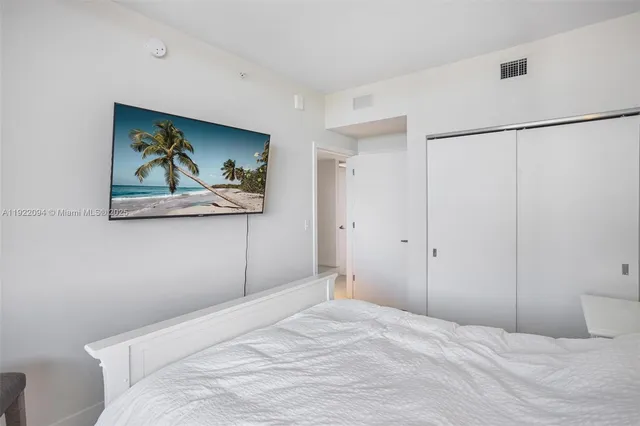 a bedroom with a bed and a painting on the wall