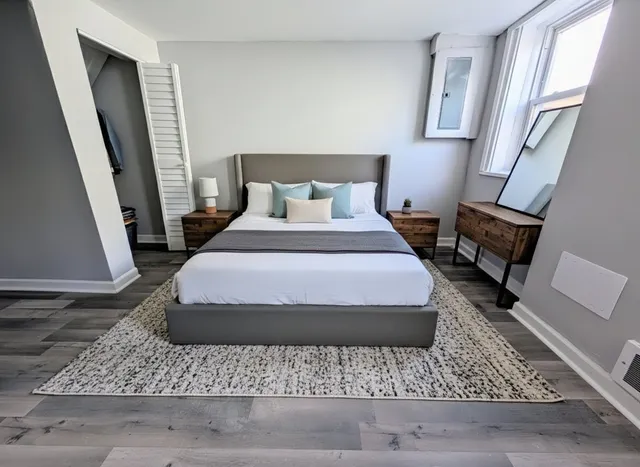 a bedroom with a bed rug and a fireplace