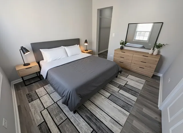 a bedroom with a bed and wooden floor