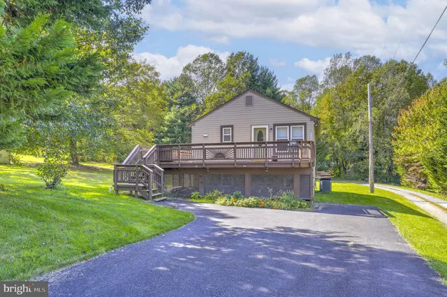 a view of a house with a swimming pool and a yard