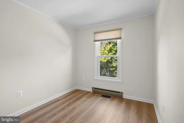 an empty room with wooden floor and a window