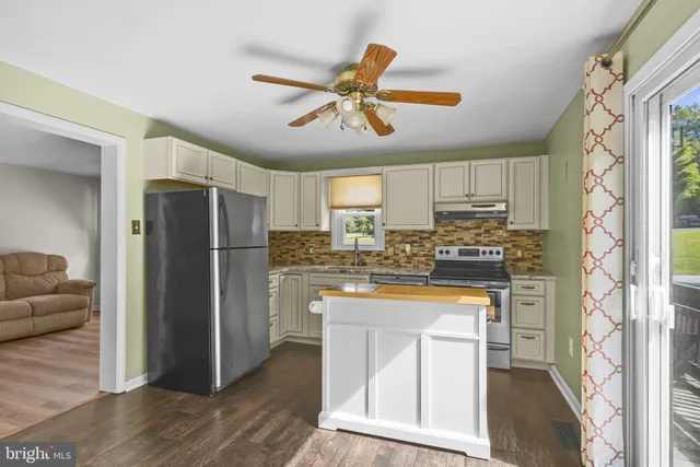 a kitchen with stainless steel appliances granite countertop a refrigerator a stove top oven a sink and dishwasher