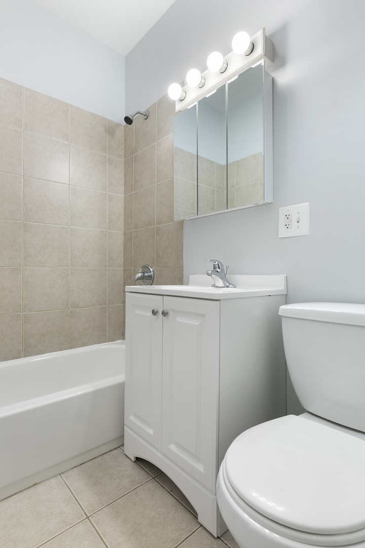 2011 West Jarvis Avenue, Unit 3 Chicago, IL 60645 - Photo 13 of 16 a bathroom with a sink a toilet and bathtub