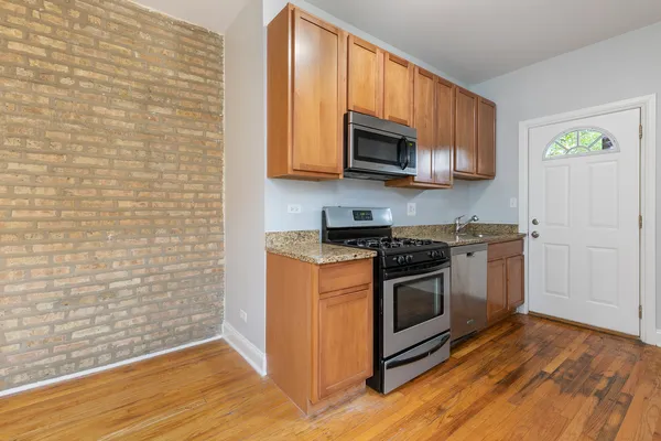 a kitchen with stainless steel appliances granite countertop a stove and a microwave